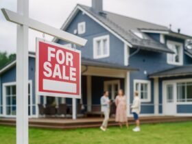 A couple talking to their realtor behind a "for sale" sign after the home inspection