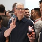 Apple CEO Tim Cook inspects the new iPhone 16 during an Apple special event at Apple headquarters.