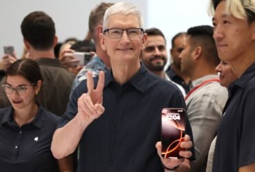 Apple CEO Tim Cook inspects the new iPhone 16 during an Apple special event at Apple headquarters.