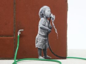 a detail of a child drinking from a green hose